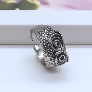 Macro shot of vintage silver owl ring detailing feather textures and adjustable band