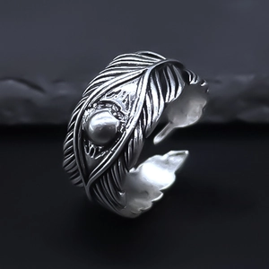 Macro detail of retro feather ring featuring vintage texture and central bead accent