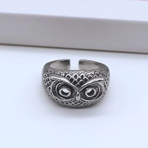 Macro detail of vintage silver owl ring featuring intricate feather textures and carvings