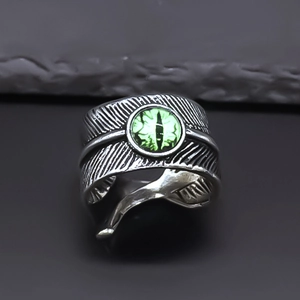 Adjustable silver feather ring with a central green evil eye stone in gothic punk style
