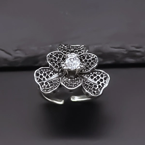 Macro shot of retro flower ring featuring black zircon pavé and white center stone
