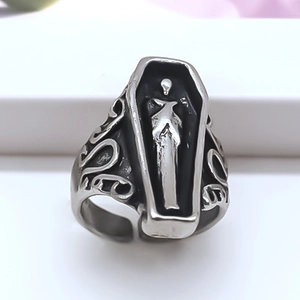 Detailed close-up of a silver gothic coffin ring featuring a 3D skull relief on a white background