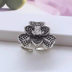 Detail of vintage silver flower ring with black spots and sparkling center zircon stone