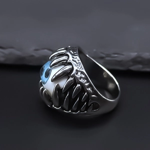 Macro detail of gothic monster eye ring with sharp silver teeth and blue eyeball focal point