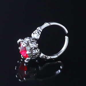 Detailed view of Gothic skeletal hand ring holding a large red ruby gemstone with reflection
