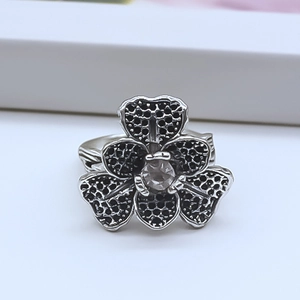 Detail of vintage silver flower ring with black honeycomb texture and central gemstone