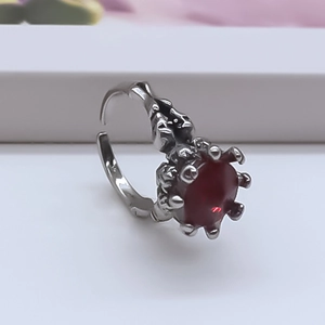 Macro shot of vintage silver-tone ring featuring a deep red oval ruby gemstone