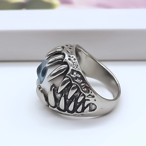 Macro shot of punk demon eye ring with blue eyeball and sharp silver metal claws
