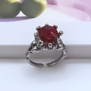 Vintage adjustable silver alloy ring featuring a large round red gemstone on white stand