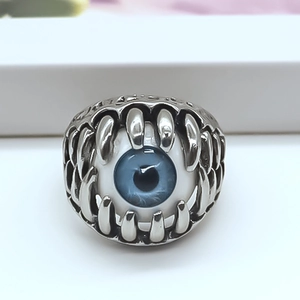 Macro shot of Gothic punk ring featuring silver claws surrounding a vivid blue demon eye