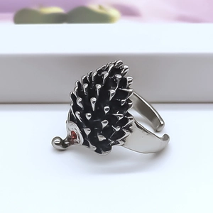 Gros plan de la bague hérisson argentée avec yeux en cristal rouge et texture noire