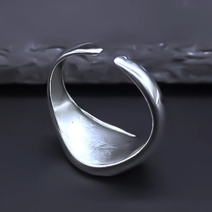Detailed macro view of the adjustable silver metal ring with a smooth minimalist texture