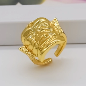 Detail of gold armor mask ring featuring 3D relief carving and adjustable open band