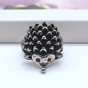 Gros plan d'une bague hérisson punk avec des yeux en strass rouges et des pointes argentées