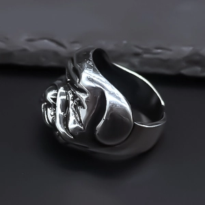 Detailed view of punk bulldog ring in retro silver alloy on a dark stone background
