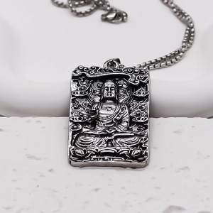 Macro shot of silver square Buddha relief pendant with vintage textured metal finish