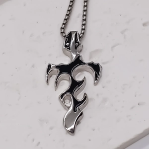 Macro detail of gothic tribal cross pendant with black enamel inlays on box chain