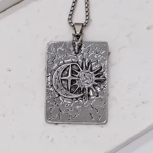 Macro detail of antique silver square pendant with sun moon relief and wolf head clasp