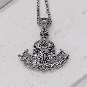 Detailed close-up of Viking axe and hammer pendant with Valknut symbol on box chain
