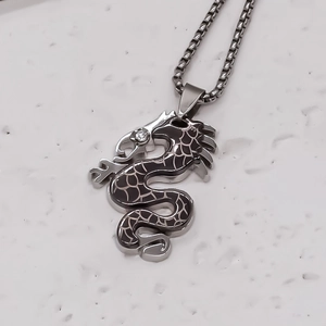 Détail du pendentif dragon en argent avec émail noir et œil en zircon sur une chaîne maille cube