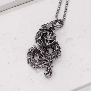 Close-up of retro dragon pendant with detailed scales on silver box chain necklace