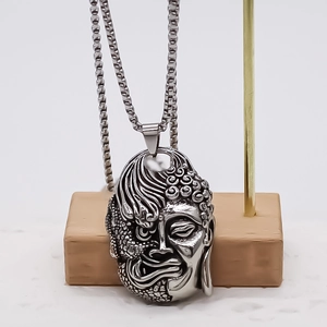Pendentif visage double Bouddha et démon en métal sculpté sur support en bois élégant