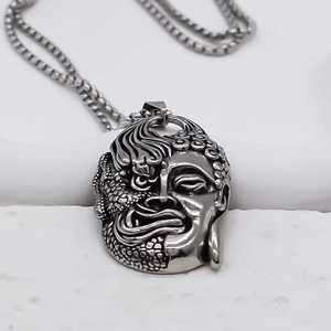Collier rétro en acier avec pendentif Bouddha et démon sur fond blanc épuré