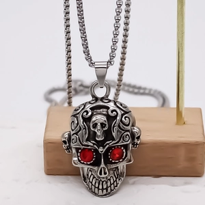 Collier pendentif crâne style punk avec yeux en strass rouges et gravures argentées