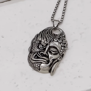 Détail du pendentif vintage montrant le design moitié Bouddha et moitié dragon texturé