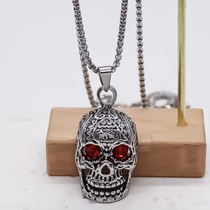 Collier gothique tête de mort en acier inox avec yeux rouges et gravures florales