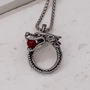 Détail collier dragon punk avec perle rouge et chaîne maille vénitienne en acier