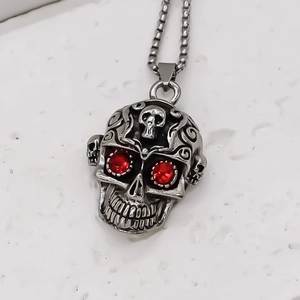 Gros plan du pendentif crâne punk vintage en argent avec yeux en pierres rouges serties