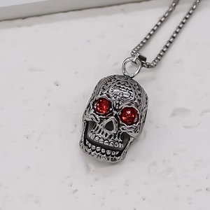 Vue détaillée du pendentif crâne gothique avec yeux en gemmes rouges et motifs floraux