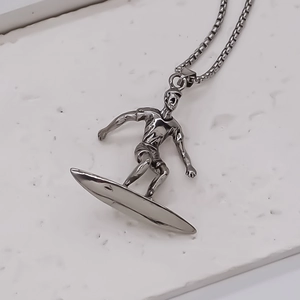 Vue macro d'un collier avec pendentif surfeur sur un fond en pierre blanche texturée