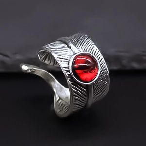 Detailed view of vintage silver feather ring with a central red eye stone in gothic style