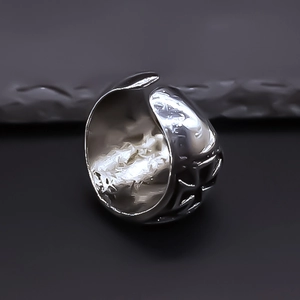 Macro view of silver adjustable cross ring with industrial lava texture and relief detail
