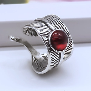 Detail of vintage feather ring with red stone inlay and oxidized silver finish
