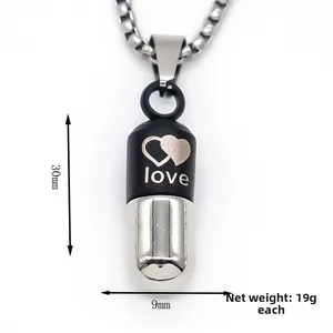 Pendentif capsule bicolore noir et argent mesurant 30 mm par 9 mm sur une chaîne