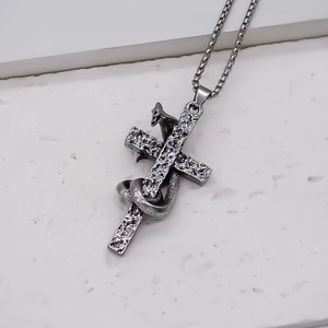 Detailed macro view of a vintage silver snake wrapped around a gothic stone cross pendant