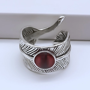 Macro shot of retro silver feather ring with a large round deep red stone inlay