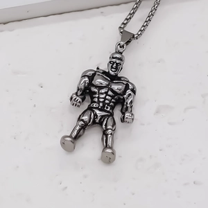 Detailed close-up of a silver muscular bodybuilder pendant necklace on white stone