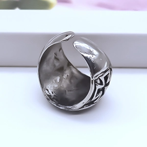 Macro detail of men's vintage cross ring featuring hammered texture and adjustable band