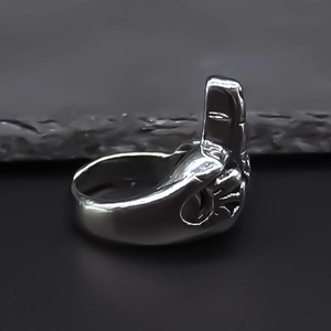 Macro detail of silver alloy finger-shaped ring featuring a middle finger punk design
