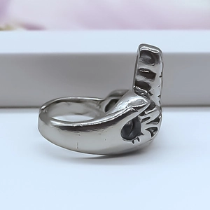 Macro shot of silver alloy middle finger gesture ring with hollowed hip hop design