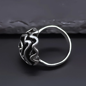 Macro shot of layered wavy textured open ring in vintage silver style with abstract curves
