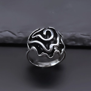 Vintage oxidized silver ring with a 3D swirl design on a dark stone background