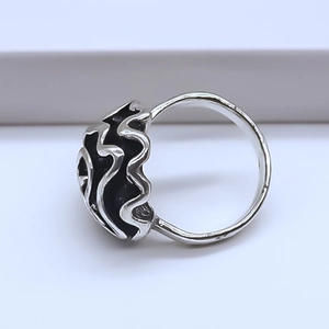Detailed side view of silver alloy ring with irregular vintage lava texture and black oxidation
