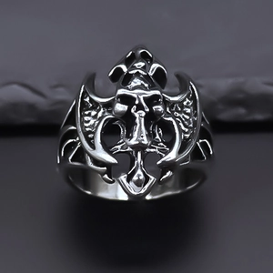 Gros plan sur une bague gothique tête de mort en argent vintage avec gravures de ailes