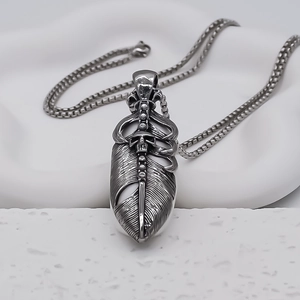Macro shot of vintage punk feather pendant with skull detail and oxidized finish chain