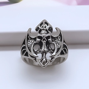 Détail d'une bague gothique tête de mort en argent vintage avec des ailes sculptées